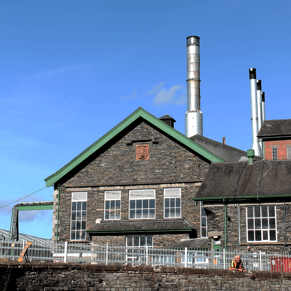 Cladirea traditionala a fabricii James Cropper, cu arhitectura industriala istorica situata pe malul raului Kent — locul unde se produce hartia înca din 1845